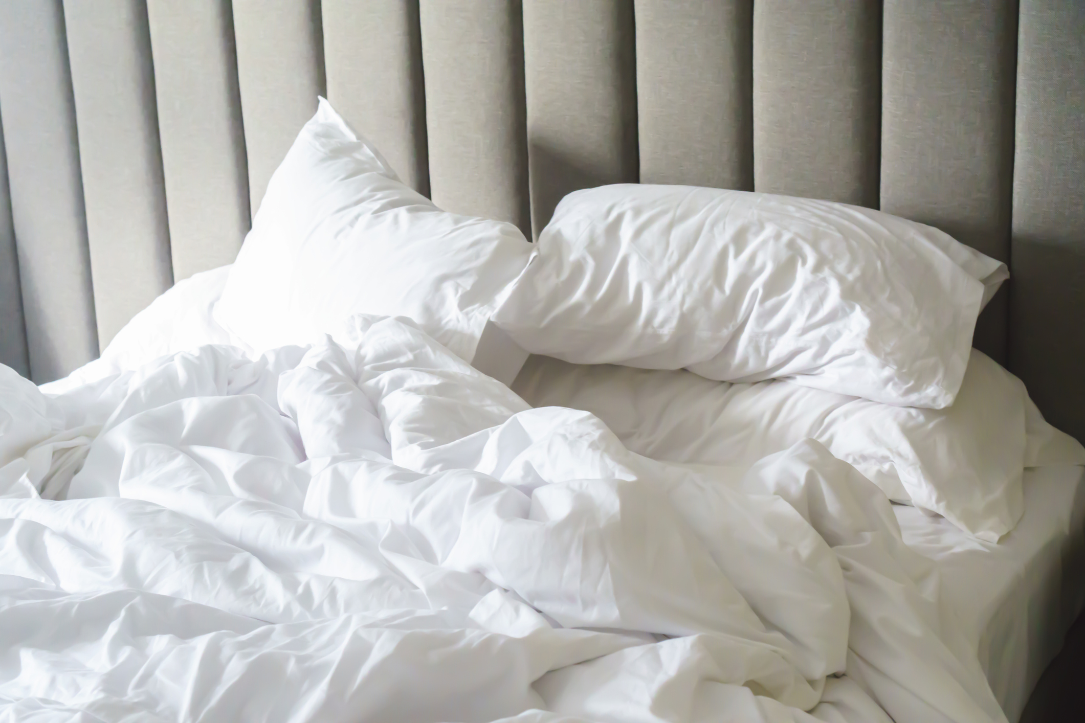 Messy bed with white sheets