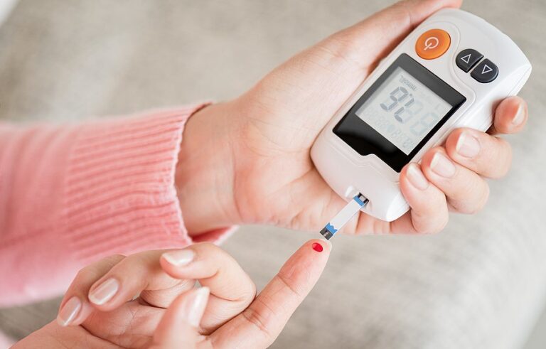 Close Up Woman Hands Checking Blood Sugar Level By Glucose Meter